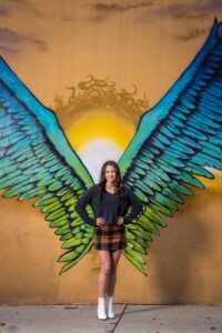 Girl in front of urban art mural