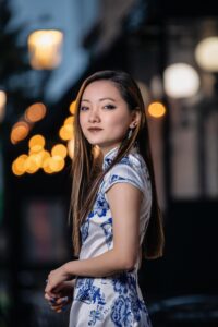 High school senior girl standing in front of local restaurant in the evening