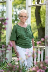 Mature women standing in front of garden arbor