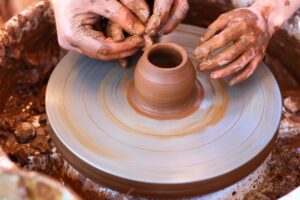 Professional brand crafter making pottery on a wheel to sell online.